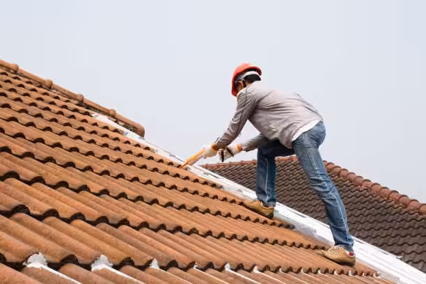 A roofer applies roof cement for roof protection tip