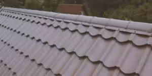 inspector checking metal roof panels for rust and damage