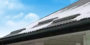 inspector checking metal roof for rust and loose fasteners